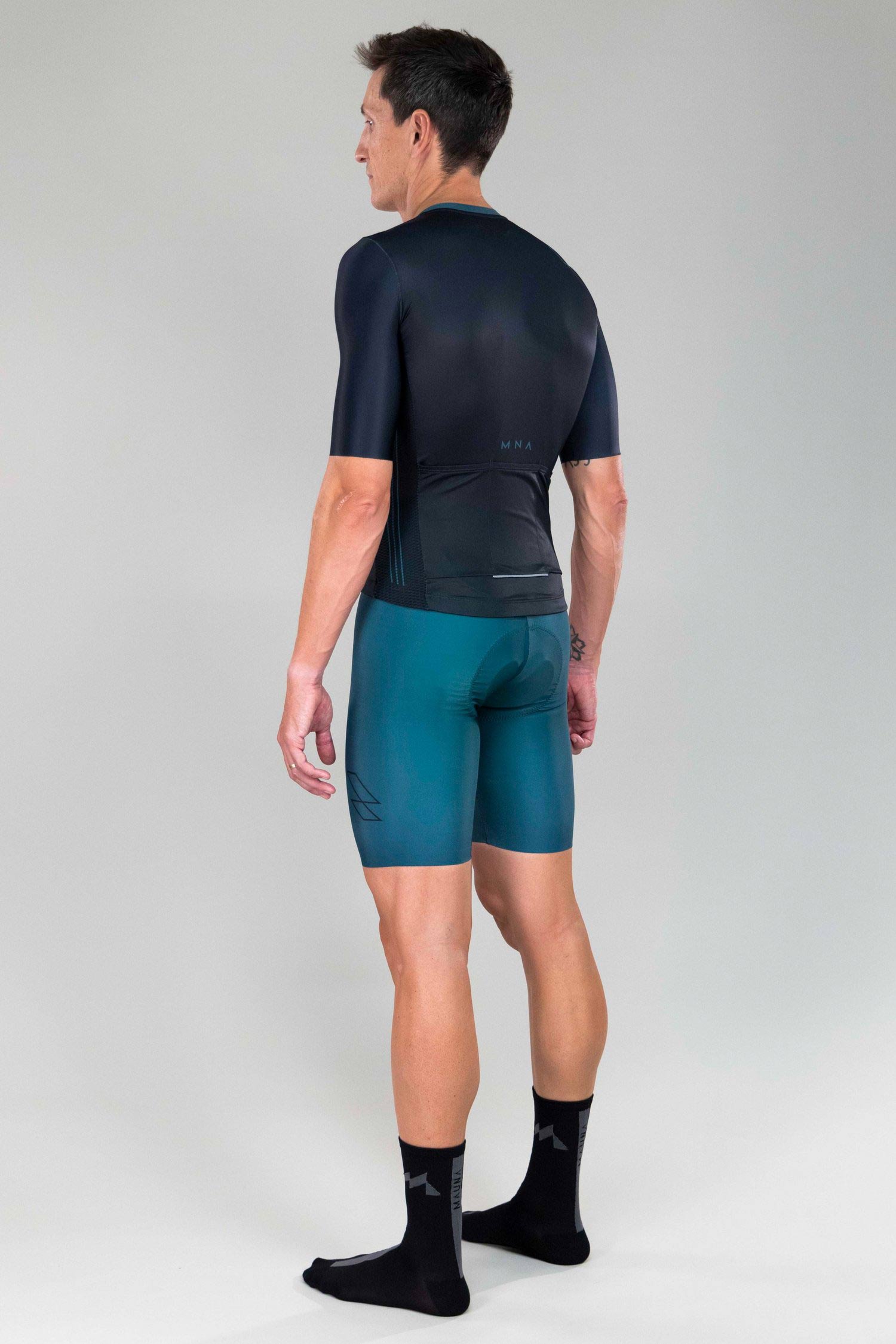 back side view of man wearing mna metsa cycling jersey