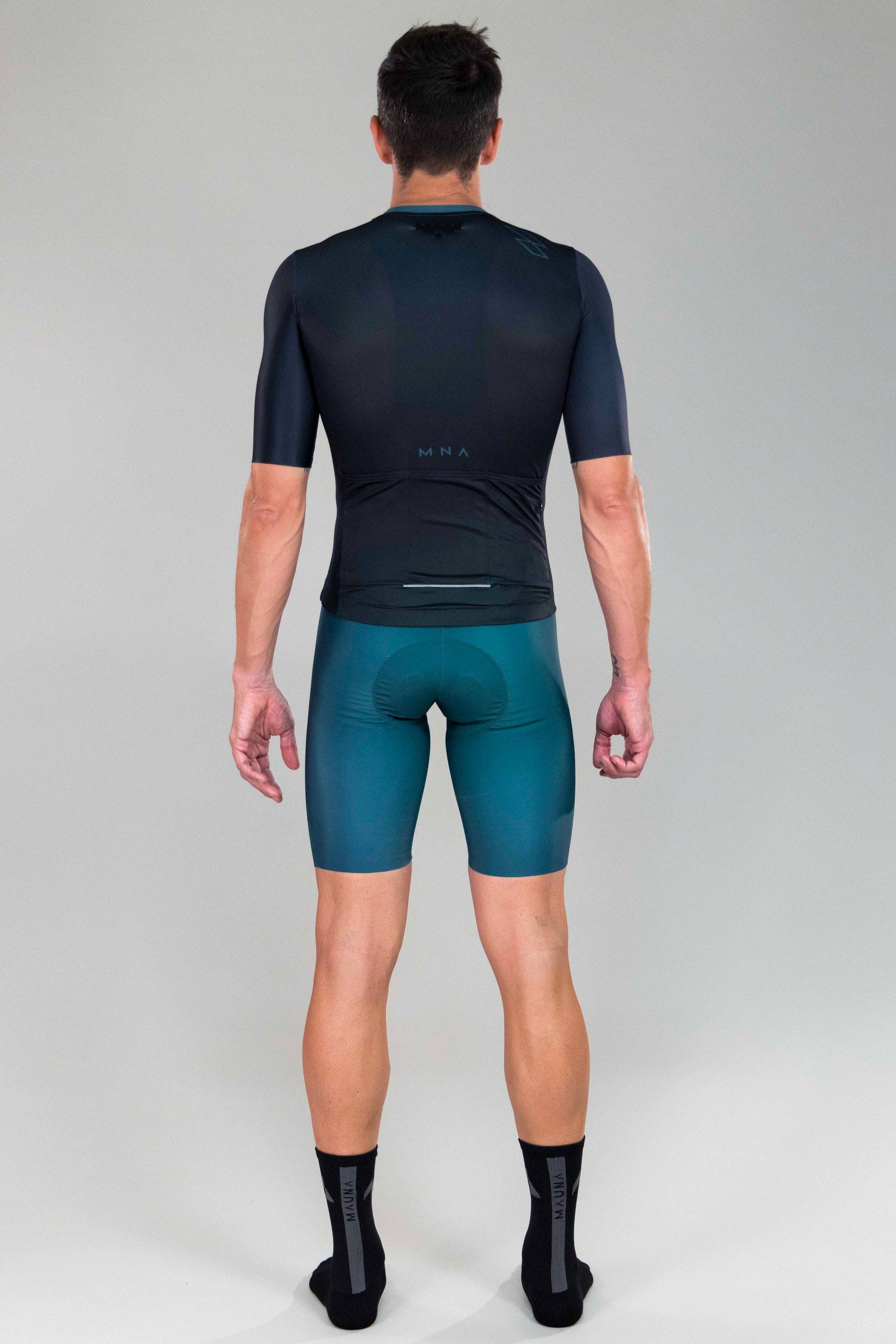 full body back view of man wearing mna metsa cycling jersey