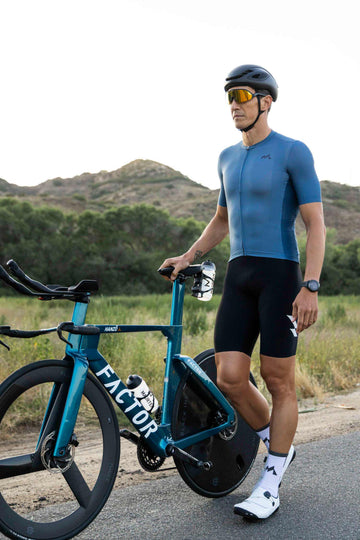 man wearing eldhraun classic cycling jersey standing next to bicycle