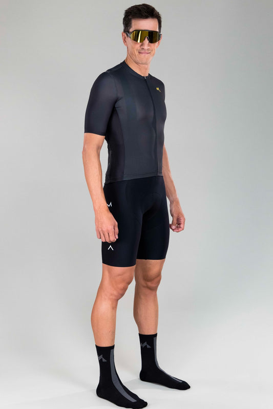 frontal right-side view of man wearing Eldhraun force cycling jersey in black