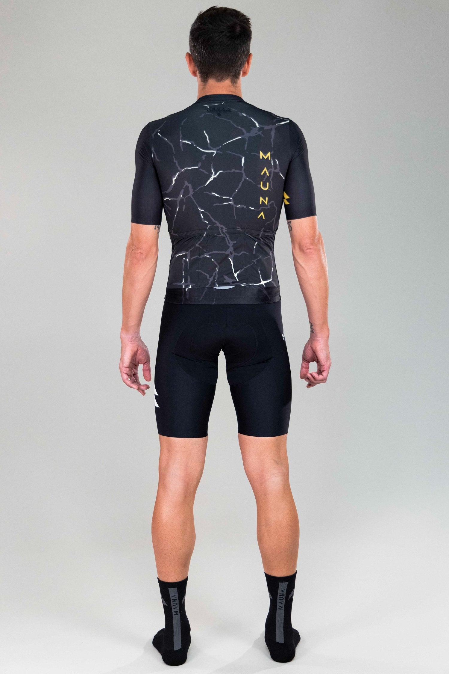 back full body view of man wearing Eldhraun force cycling jersey in black