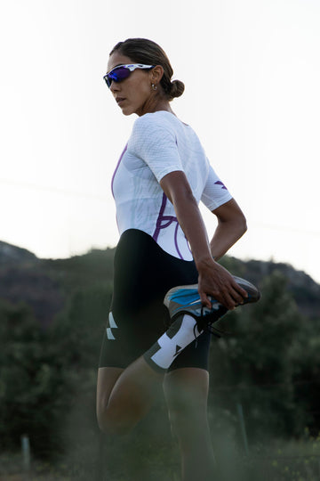 woman holding foot behind her wearing women's eldhraun pr race trisuit
