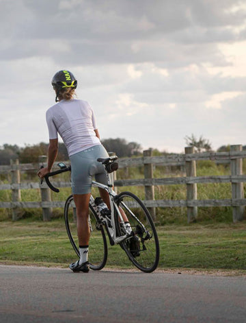 back view of woman stopped on bike wearing mna metsa training collection