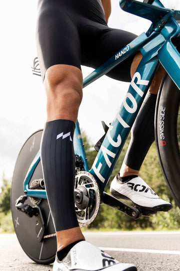Close-up view of a person idle on bike wearing Mauna Aero CalfSleeves
