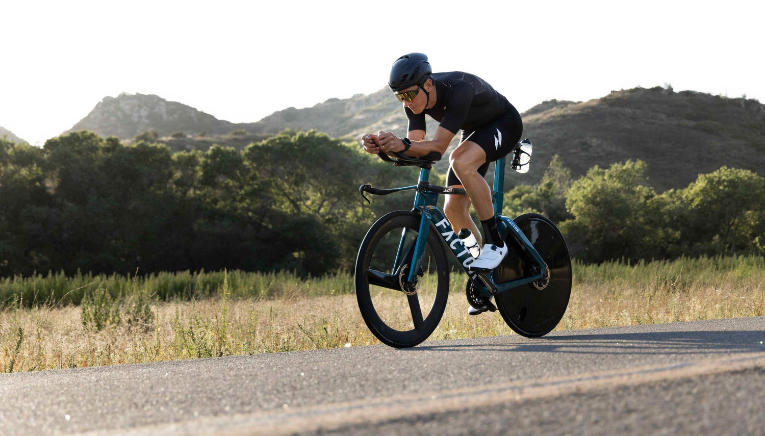 man cycling wearing mauna's trisuit in black