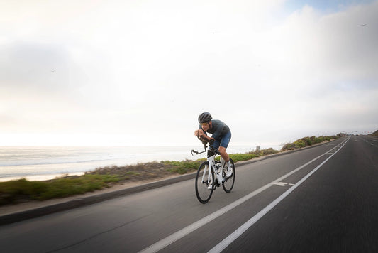 Cycling athlete riding on the highway along the coastline