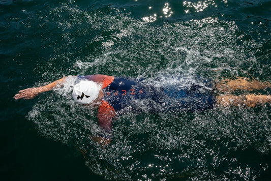above view of a woman swimming wearing Mauna swim cap and wetsuit